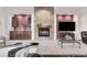 Inviting living room featuring a stone fireplace, built-in bar, and neutral carpeting at 10024 Scenic Walk Ave, Las Vegas, NV 89149