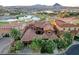 A high-angle bird's eye view of a luxury home with red tile roof and lush landscaping near a serene lake at 15 Rue Du Rivoli Pl, Henderson, NV 89011