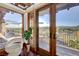 Elegant balcony view with wood floors, glass doors, white chair, and a glimpse of the scenic landscape at 15 Rue Du Rivoli Pl, Henderson, NV 89011