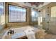 Bathroom featuring a tile window, marble finishes, a soaking tub, and glass enclosed shower at 15 Rue Du Rivoli Pl, Henderson, NV 89011