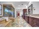 Luxurious bathroom featuring a walk-in shower, soaking tub, and dual vanities with wood cabinetry at 15 Rue Du Rivoli Pl, Henderson, NV 89011