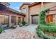 Charming courtyard featuring a custom wood door, lush greenery, and cozy seating, creating a welcoming entrance at 15 Rue Du Rivoli Pl, Henderson, NV 89011