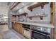 Gourmet kitchen area featuring wooden cabinets and shelves, and stainless steel appliances at 15 Rue Du Rivoli Pl, Henderson, NV 89011