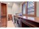 Bright laundry room with wood cabinets, counter space, modern washer/dryer, and a natural light window at 15 Rue Du Rivoli Pl, Henderson, NV 89011