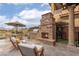 Inviting outdoor living area with a stone fireplace, built-in grill, comfortable seating, and picturesque views at 15 Rue Du Rivoli Pl, Henderson, NV 89011