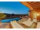 Spacious outdoor living area with an infinity pool, comfortable seating, and lush landscaping at 15 Rue Du Rivoli Pl, Henderson, NV 89011