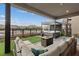 Covered patio with a hot tub, fire pit, and seating overlooking the lake at 16 Heron Harbour Dr, Henderson, NV 89011