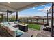 Covered patio with plush seating, fire pit, and a view of the lake at 16 Heron Harbour Dr, Henderson, NV 89011