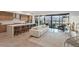Open-concept living space with modern kitchen, sleek island, and expansive sliding glass doors leading to outdoor balcony at 16 Heron Harbour Dr, Henderson, NV 89011
