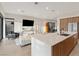 Open floor plan with island seating connecting the modern kitchen and spacious living area with lots of sunlight at 16 Heron Harbour Dr, Henderson, NV 89011