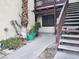 Condo entrance with stairs, mature palm trees, and various potted plants at 3168 S Eastern Ave # 45, Las Vegas, NV 89169