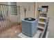 A modern gray AC unit sits outside next to a silver aluminum ladder against a stucco wall at 4156 Balmoral Castle Ct, Las Vegas, NV 89141