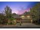 Beautiful two-story home with a three-car garage, landscaped front yard and elegant brick entryway at dusk at 4156 Balmoral Castle Ct, Las Vegas, NV 89141
