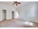 Large carpeted bedroom with ceiling fan, closet with sliding doors, and neutral wall paint at 7908 Morning Gallop Ct, Las Vegas, NV 89131