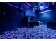 Entertainment room featuring blue lighting, custom carpet, a desk and shelving, and projector at 7908 Morning Gallop Ct, Las Vegas, NV 89131
