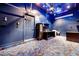 Entertainment room with custom carpet, desk and shelving, projector setup, and blue painted walls at 7908 Morning Gallop Ct, Las Vegas, NV 89131