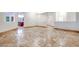 Empty living area showcasing travertine flooring and a view into the kitchen at 7908 Morning Gallop Ct, Las Vegas, NV 89131