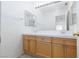 Bright bathroom with double sinks, wood cabinets, bright lights, and ample mirror space at 8516 Montago Valley Ave, Las Vegas, NV 89117