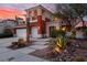 Inviting two-story home featuring a red and tan exterior, complemented by desert landscaping and a three car garage at 8516 Montago Valley Ave, Las Vegas, NV 89117