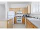 Kitchen with island, light wood cabinets, white appliances and shutters on the window at 8516 Montago Valley Ave, Las Vegas, NV 89117