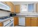 Kitchen with light wood cabinets, white appliances, range, and plantation shutters at 8516 Montago Valley Ave, Las Vegas, NV 89117