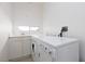Bright laundry room with white washer and dryer, sink, and storage cabinets at 8516 Montago Valley Ave, Las Vegas, NV 89117