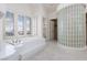Large primary bathroom with soaker tub, see-through shower and views at 8516 Montago Valley Ave, Las Vegas, NV 89117