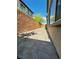 View of the backyard showcasing desert landscaping, a brick privacy wall, and a paved patio area at 8920 Appellation Ave, Las Vegas, NV 89148