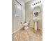 Cozy bathroom with tile floors, pedestal sink, toilet, and window for natural light at 8920 Appellation Ave, Las Vegas, NV 89148