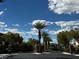 Gated community entrance with mature landscaping and a beautiful blue sky backdrop at 8920 Appellation Ave, Las Vegas, NV 89148