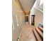 Inviting hallway with tile flooring, textured walls, and staircase with carpeted steps at 8920 Appellation Ave, Las Vegas, NV 89148
