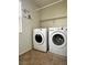 Bright laundry room with white washer and dryer set and neutral tile flooring at 8920 Appellation Ave, Las Vegas, NV 89148
