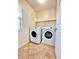Well-lit laundry room featuring a washer, dryer and shelving above, providing ample storage space at 8920 Appellation Ave, Las Vegas, NV 89148