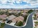 Aerial view of a neighborhood with mature landscaping, tile roofs, and mountain views at 1501 Via Salaria Ct, Henderson, NV 89052