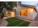 Backyard with artificial turf, mature landscaping, and large picture window at 1501 Via Salaria Ct, Henderson, NV 89052