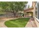 View of the backyard features manicured synthetic lawn and a covered patio at 1501 Via Salaria Ct, Henderson, NV 89052
