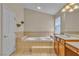 Bathroom featuring a soaking tub and wood cabinets at 1501 Via Salaria Ct, Henderson, NV 89052