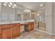 Bathroom featuring dual sinks, wood cabinets, and glass-enclosed shower at 1501 Via Salaria Ct, Henderson, NV 89052