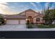 Beautiful single-story home with a three-car garage, desert landscaping, and a stone facade under a blue sky at 1501 Via Salaria Ct, Henderson, NV 89052