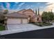 Beautiful home with brick accents, a well-maintained lawn, and a large driveway leading to a garage at 1501 Via Salaria Ct, Henderson, NV 89052