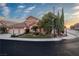 Inviting home exterior featuring lush landscaping, mature trees, and a circular driveway at 1501 Via Salaria Ct, Henderson, NV 89052