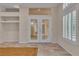 Living room with tiled floor, French doors, and custom window shutters at 1501 Via Salaria Ct, Henderson, NV 89052