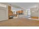 Living room featuring a stone fireplace, a wet bar, and an open view to the kitchen at 1501 Via Salaria Ct, Henderson, NV 89052