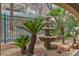 The backyard boasts a beautiful stone water fountain surrounded by palm trees at 1501 Via Salaria Ct, Henderson, NV 89052