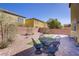 A backyard with a small patch of turf and a dark patio set on brick pavers at 320 Point Loma Ave, North Las Vegas, NV 89031