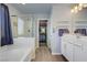 Bright bathroom boasts a walk-in shower, bathtub, and white vanity with closet access at 320 Point Loma Ave, North Las Vegas, NV 89031