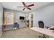 Bright bedroom featuring a ceiling fan, colorful curtains, and desks for a functional workspace at 320 Point Loma Ave, North Las Vegas, NV 89031