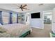Bright bedroom featuring a ceiling fan, TV, en suite access, and a floral-patterned bedspread at 320 Point Loma Ave, North Las Vegas, NV 89031