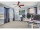 A bedroom filled with two monitors, neutral walls, three windows, and a ceiling fan at 320 Point Loma Ave, North Las Vegas, NV 89031