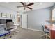 A dual desk bedroom has two monitors, blue colored walls, ceiling fan, and ensuite bathroom access at 320 Point Loma Ave, North Las Vegas, NV 89031